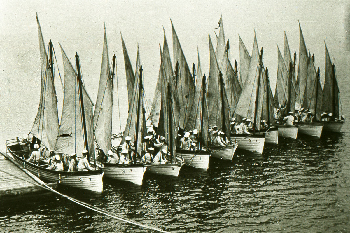 Historic group photo of ship’s boys and officers aboard the vessel Jarramas, all dressed in uniforms and sailor caps.