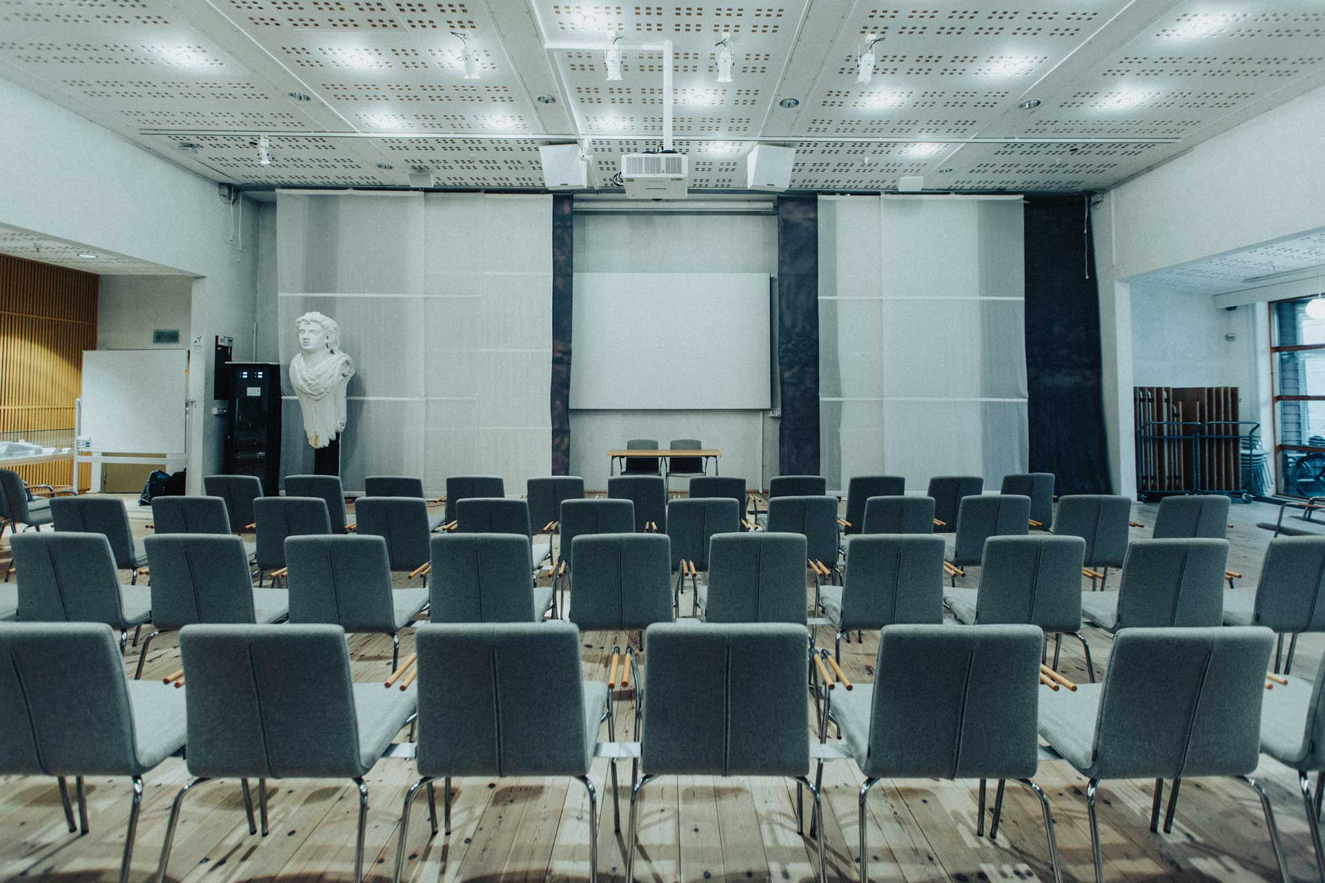 En grupp personer sitter i en föreläsningssal på Marinmuseum och lyssnar uppmärksamt och leende under en presentation.
