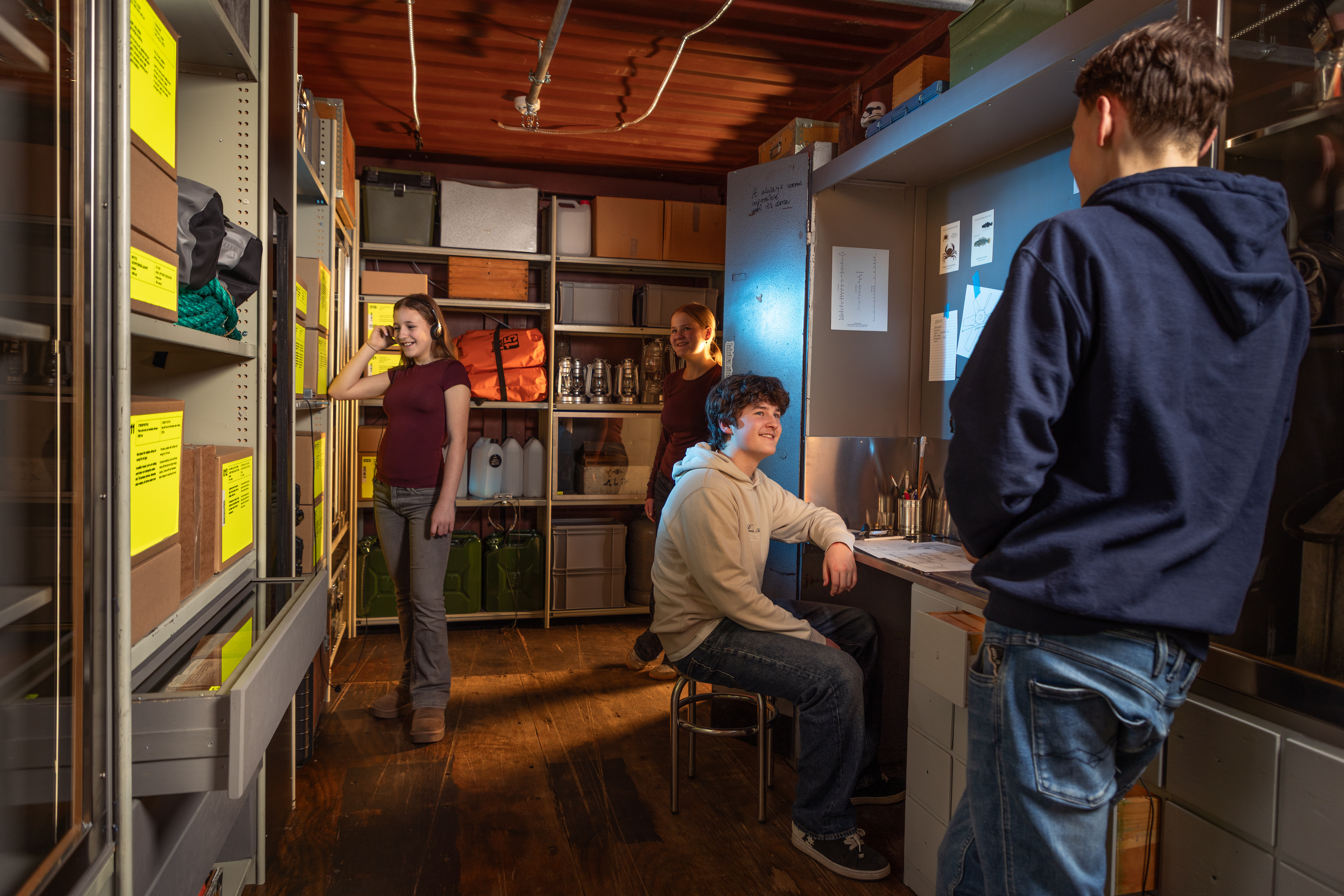 Four teenagers explore the storage room on the Future Ship exhibit.