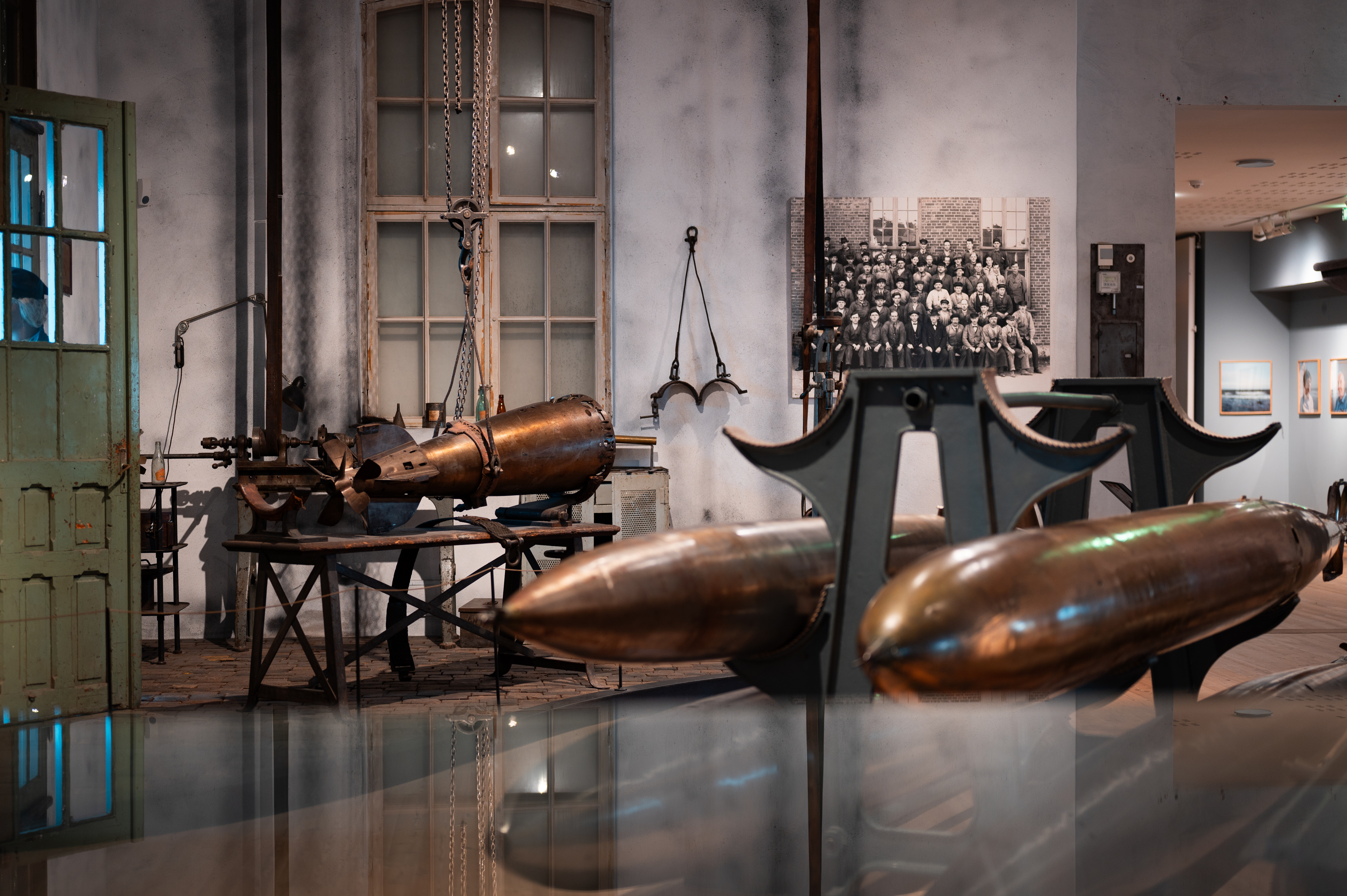 Historic ship engines are displayed in a historic setting.