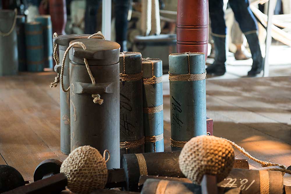 Krutladdningar och ammunition uppställda på kanondäck i utställningen.