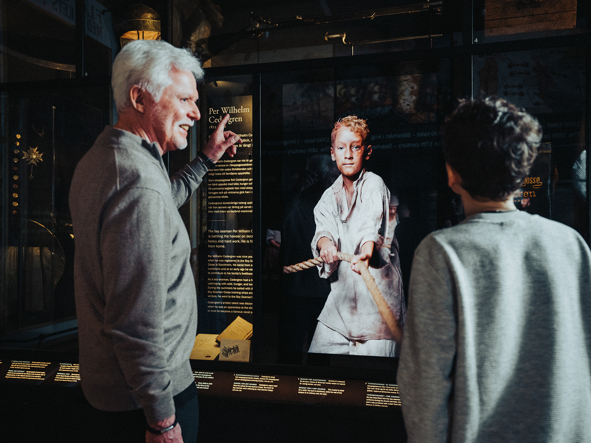 Två besökare tittar på en interaktiv del av utställningen på Marinmuseum som berättar om livet till sjöss.