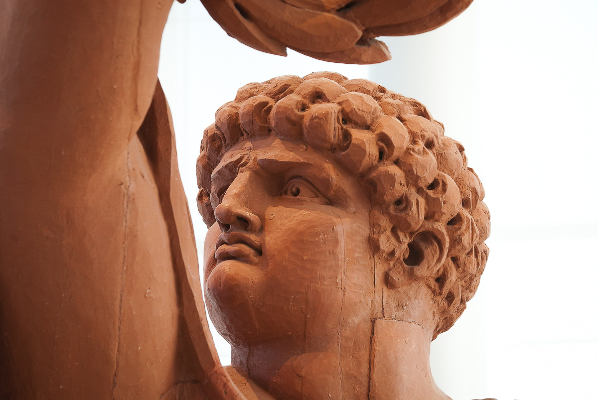 Närbild av galjonsfiguren Äran i terrakottafärg på Marinmuseum i Karlskrona.