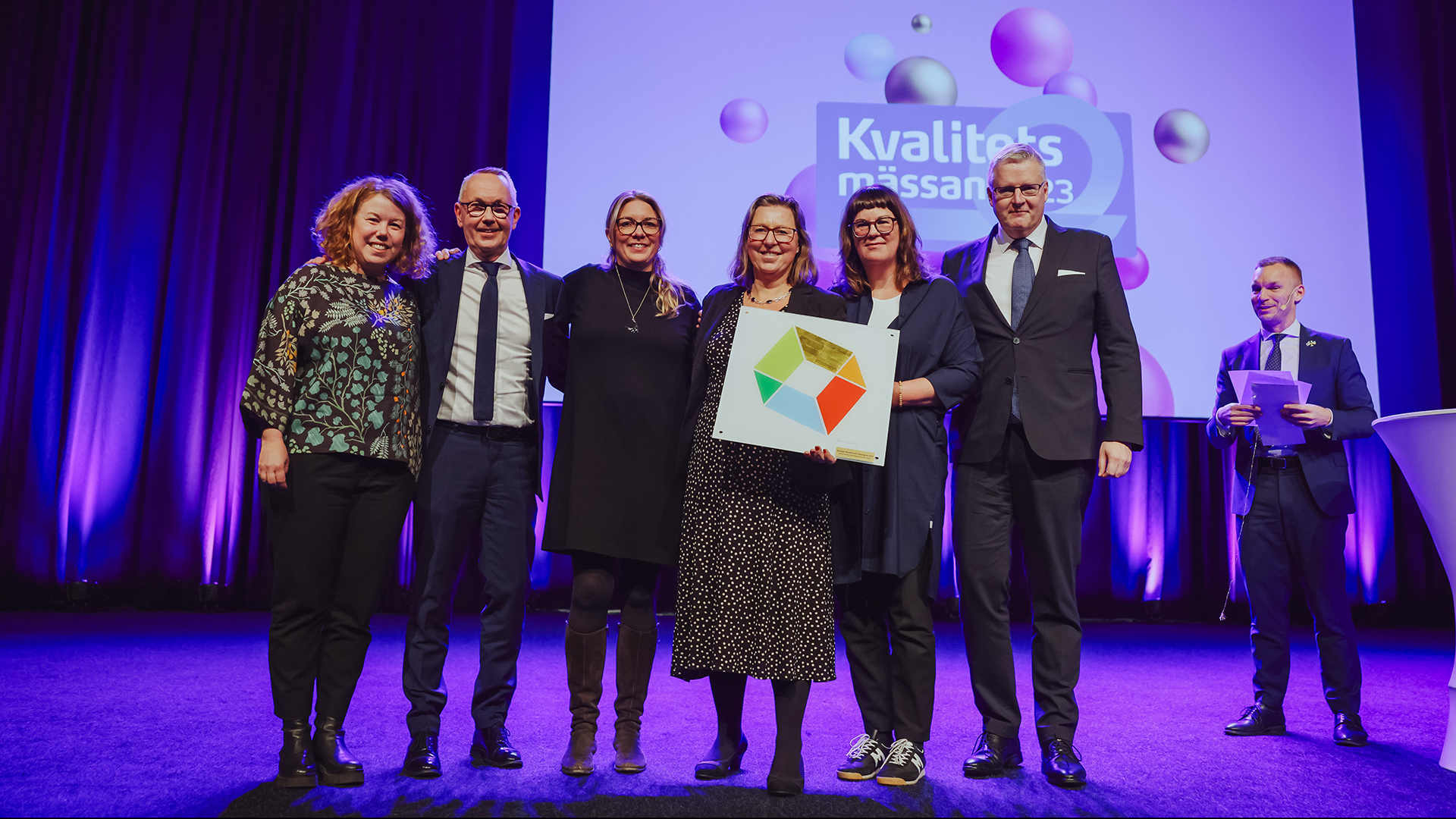Finklädda personer på en scen som tar emot pris på en prisutdelning.
