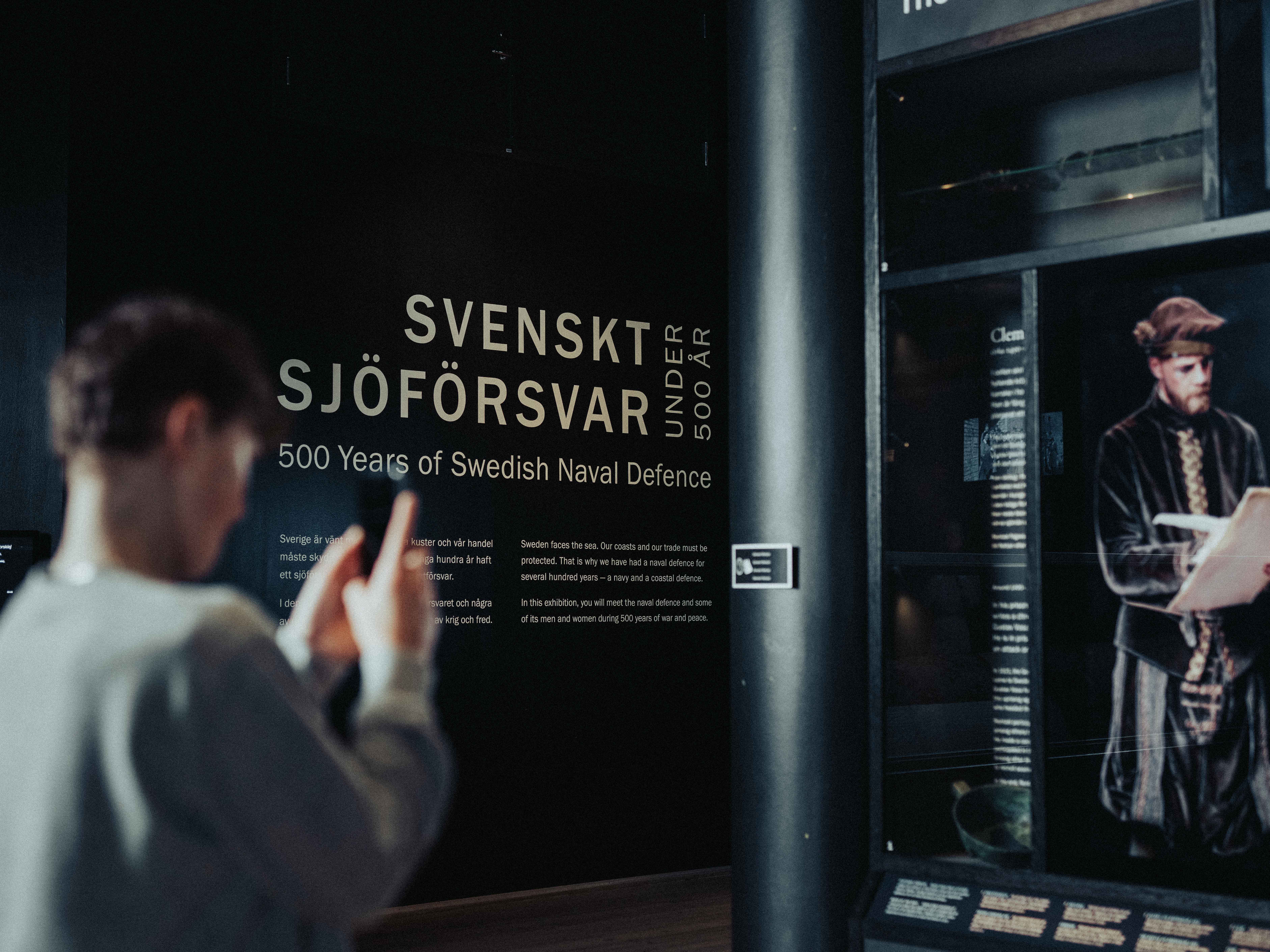 En pojke tar en bild på en utställning med sin mobiltelefon